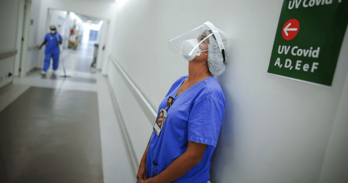Mulher encostada na parede do hospital